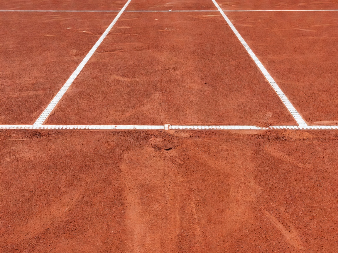 Tennis court baseline lines and red clay texture
